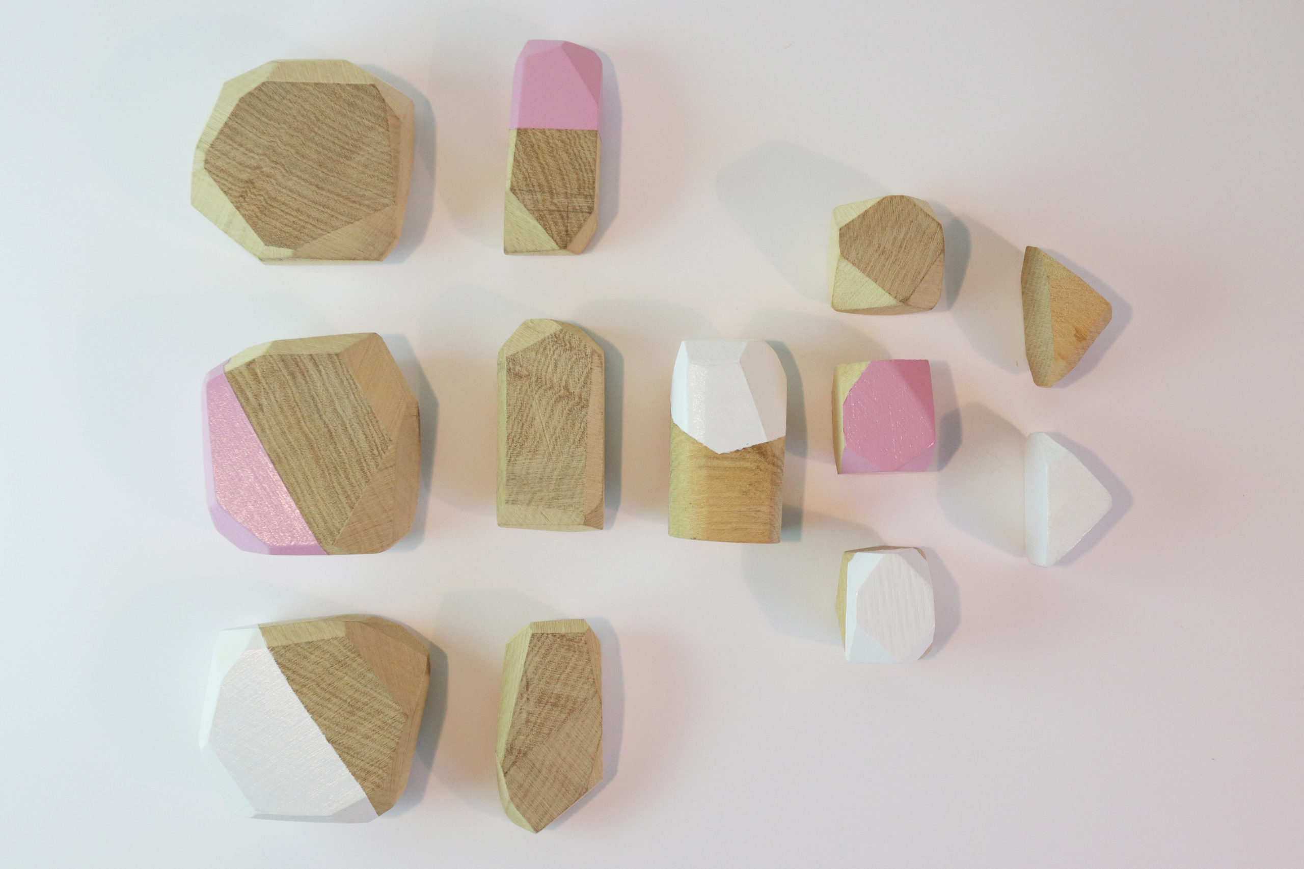 Présentation de l'ensemble des pieces blanches et roses. Jeux d'équilibre en pierre de bois de chêne.